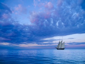 ancient two-mast schooner sailing away to the horizon